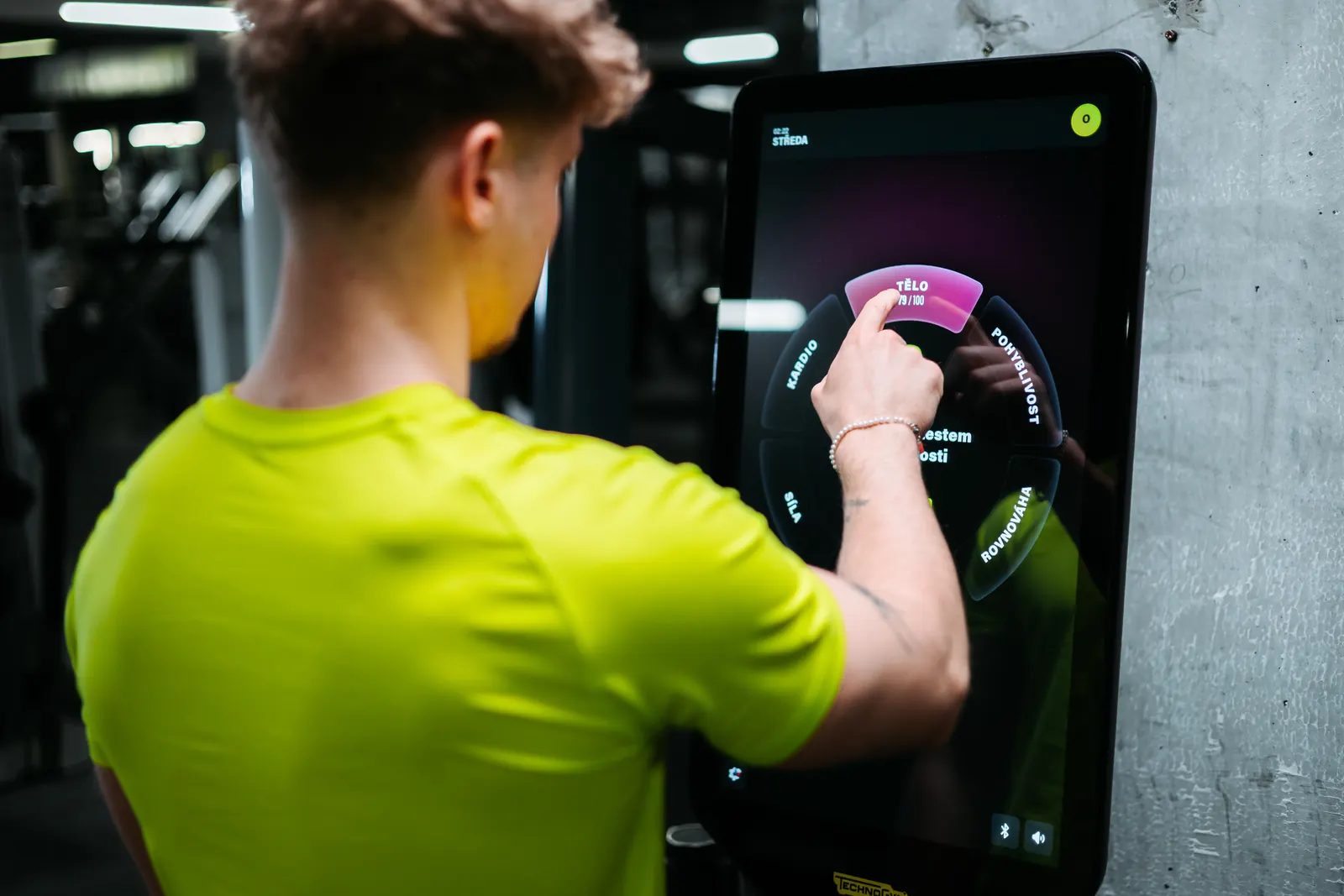Klient si na dotykovém displeji prohlíží kruhový přehled výsledků Checkupu