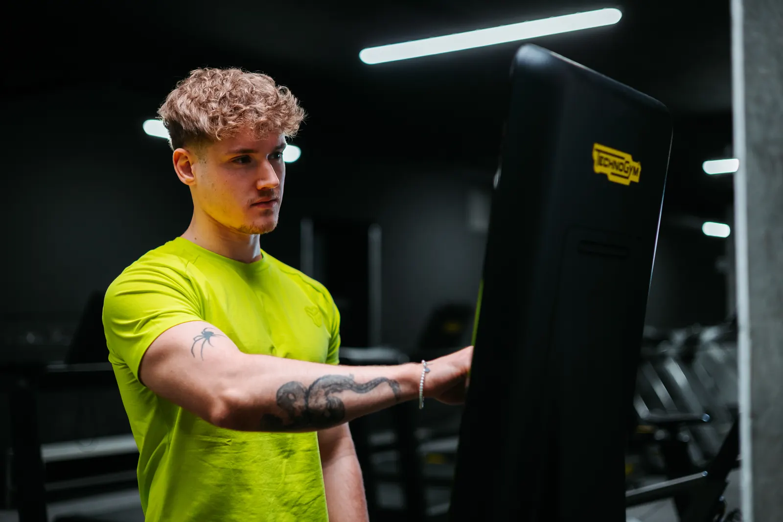 Klient se dívá na displej zařízení Technogym Checkup v posilovně 210 GYM